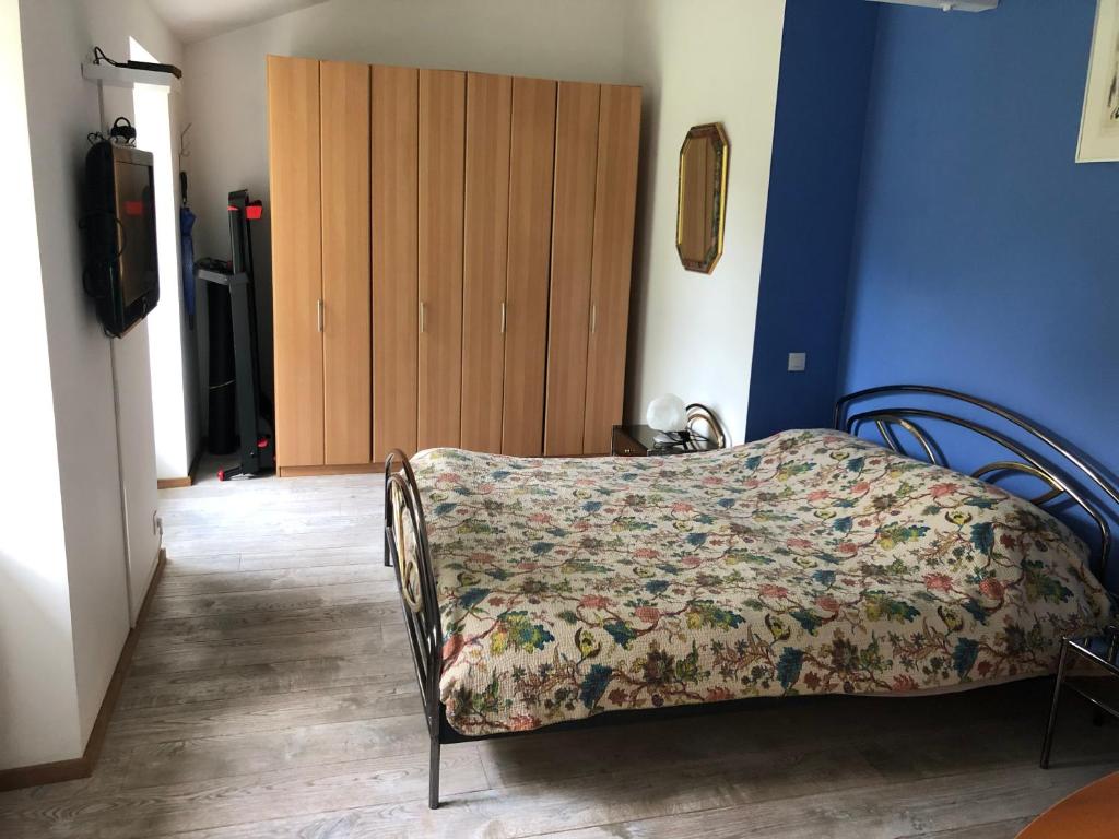 a bedroom with a bed with a floral blanket on it at Saint Vivien de Médoc: jolie maison médocaine in Saint-Vivien-de-Médoc