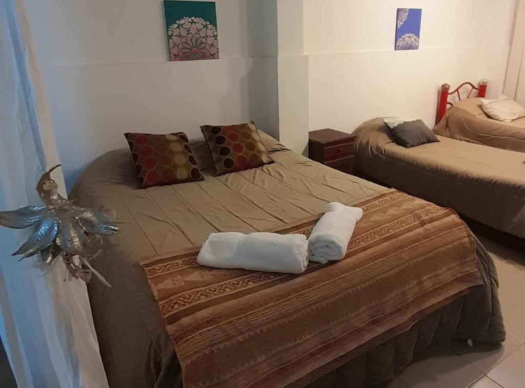 a bedroom with two beds with towels on them at Monoambiente Centrico Amplio in Tandil