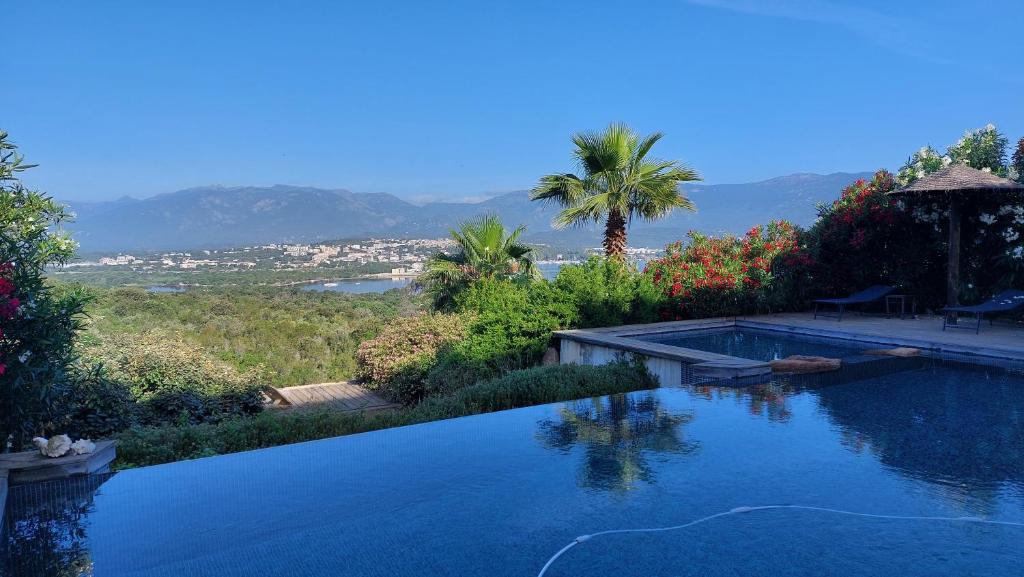 une piscine avec vue sur les montagnes dans l'établissement La baie des anges, à Porto-Vecchio