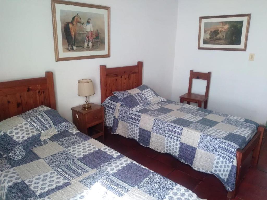 Dos camas una al lado de la otra en un dormitorio. en Don Luis Bueno, en Carmen de Areco