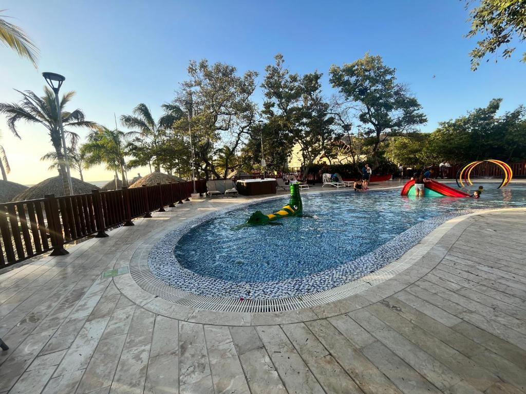 een zwembad met kinderen die spelen in het water in een park bij Samaria Club de Playa in Santa Marta