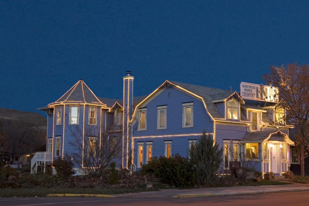 a large blue house with its lights on at Heartwood Inn in Drumheller