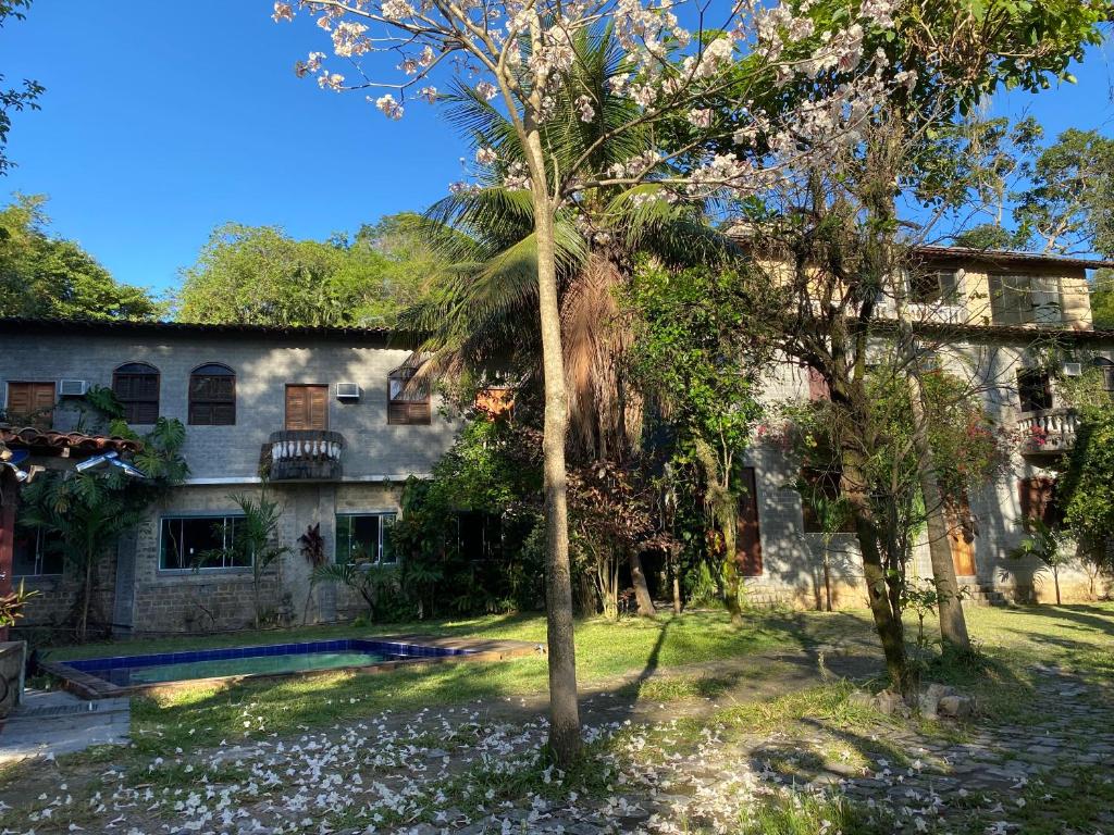 una casa vieja con una palmera en el patio en Rio Natureza apart 109, en Río de Janeiro