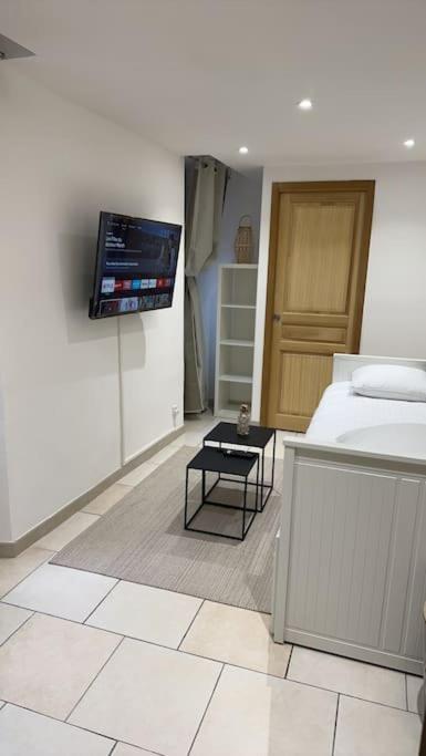 une chambre avec un lit et une télévision sur un mur dans l'établissement Studio en plein cœur du centre historique !, à Nyons