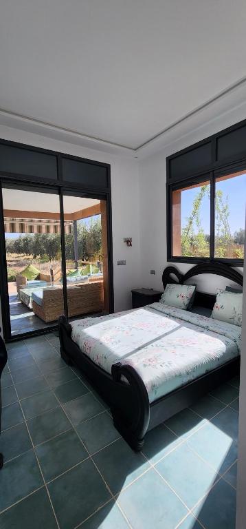 - une chambre avec un grand lit et 2 fenêtres dans l'établissement LA FINCA, à Marrakech