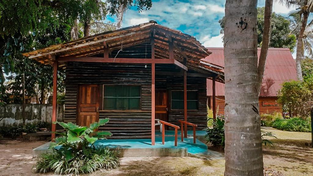 a small wooden house with a tree in front of it at Pousada Boto in Salvaterra