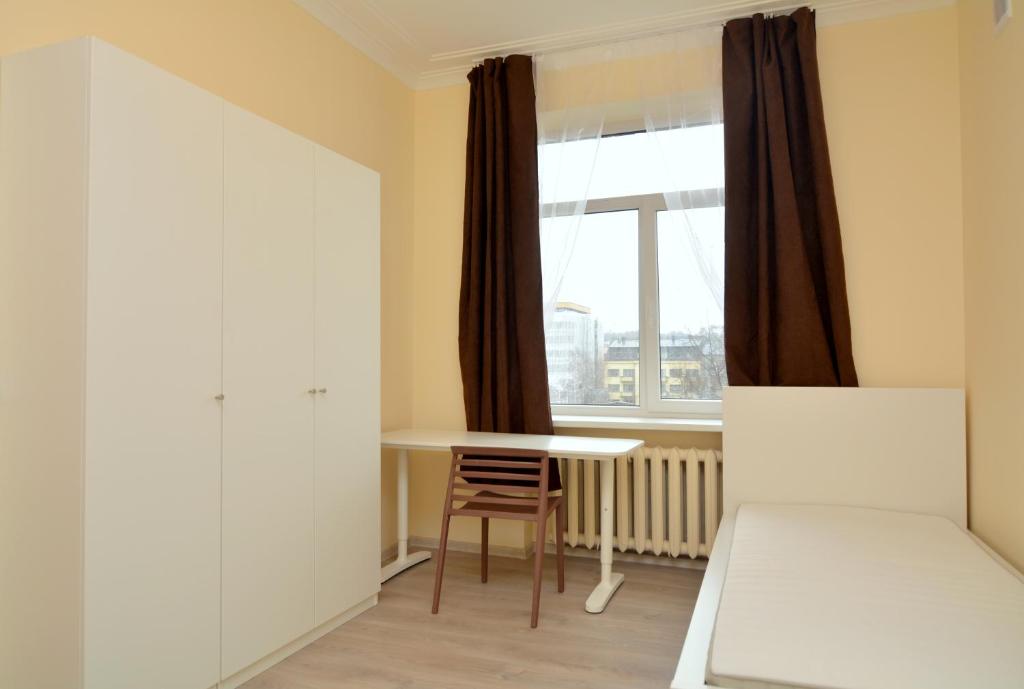Habitación pequeña con mesa y ventana en Daukanto st 3 Kaunas Students Home LT en Kaunas