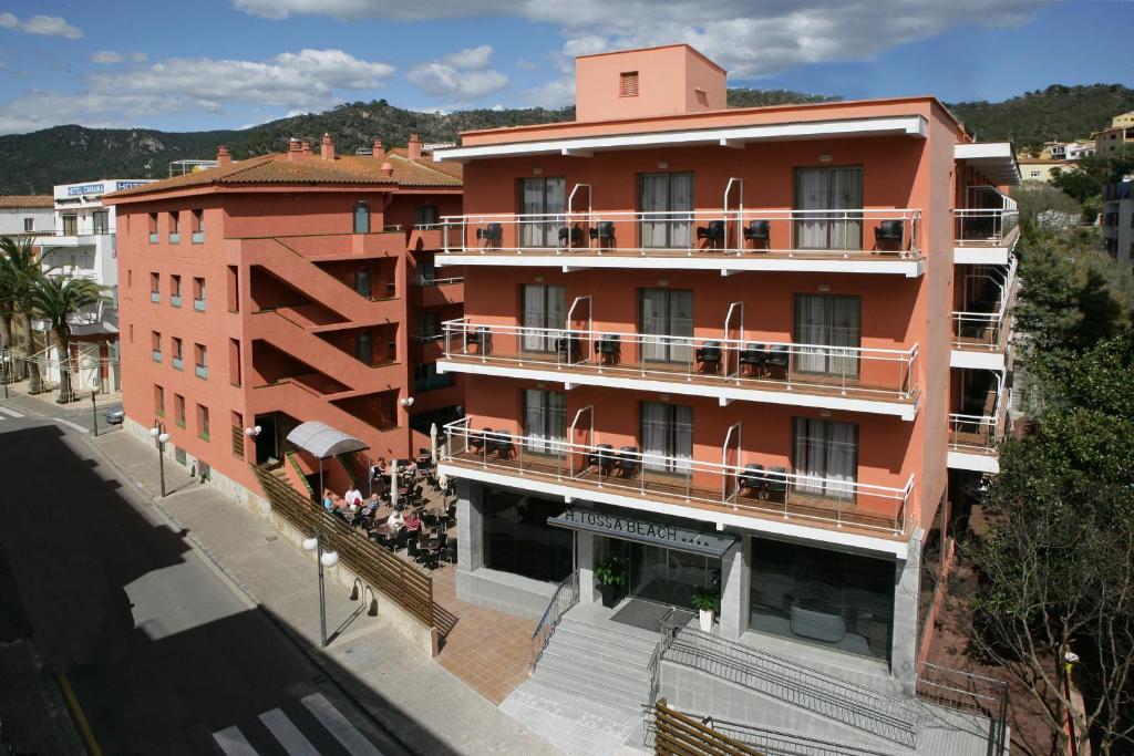 an orange building with a balcony on a street at Tossa Beach Center in Tossa de Mar