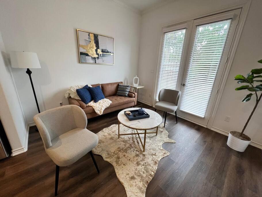 ein Wohnzimmer mit einem Sofa und einem Tisch in der Unterkunft Urban chic living minutes to I-45 and I-610 #B in Houston
