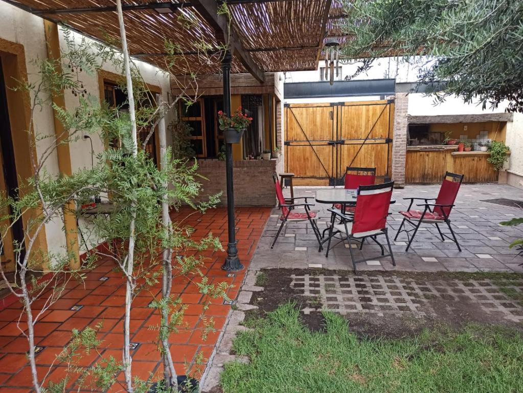 a patio with chairs and a table and a fence at Habitación privada cerca del centro in Godoy Cruz