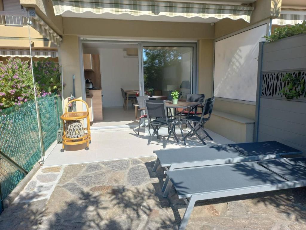 un patio avec une table et des chaises dessus dans l'établissement T1 climatisé avec jardin, piscine, tennis, à 750m de la plage - Parc Des Oliviers - FR-1-610-85, à Bormes-les-Mimosas