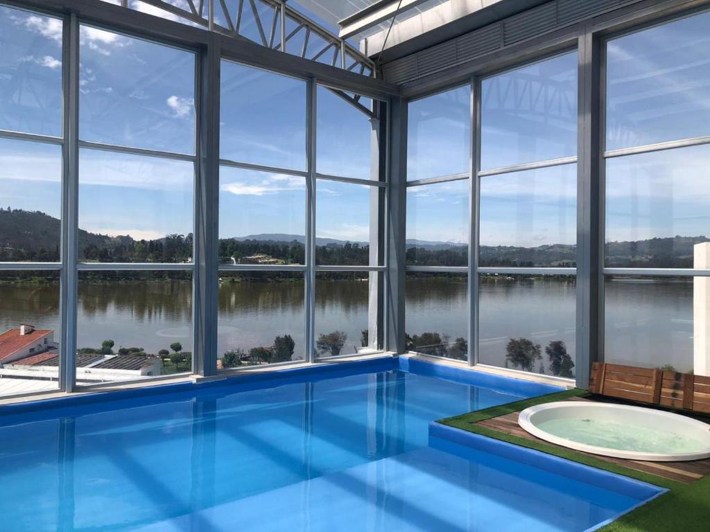 - une grande piscine avec vue sur l'eau dans l'établissement Lujoso Apartamento Cerca al Lago Sochagota en Paipa, à Paipa