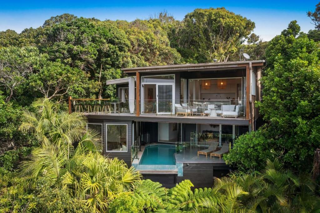 an image of a house with a pool and trees at Elouera in Byron Bay