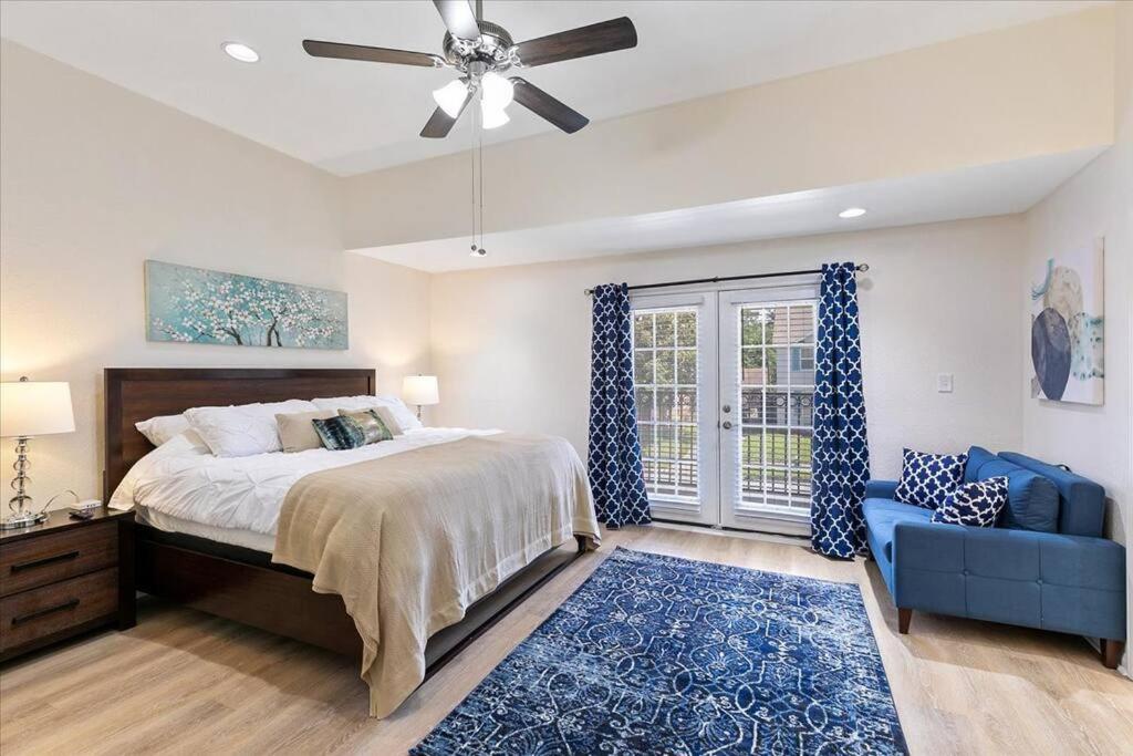 a bedroom with a bed and a ceiling fan at Bring the Crew! 4BR Luxe Pad, Backyard Magic & City at Your Door in Houston