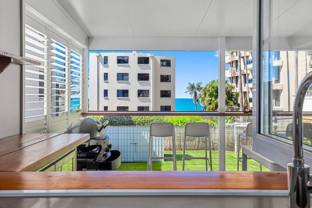 a kitchen with a large window with a view of a yard at Luxury Coastal Retreat in Coolum Beach