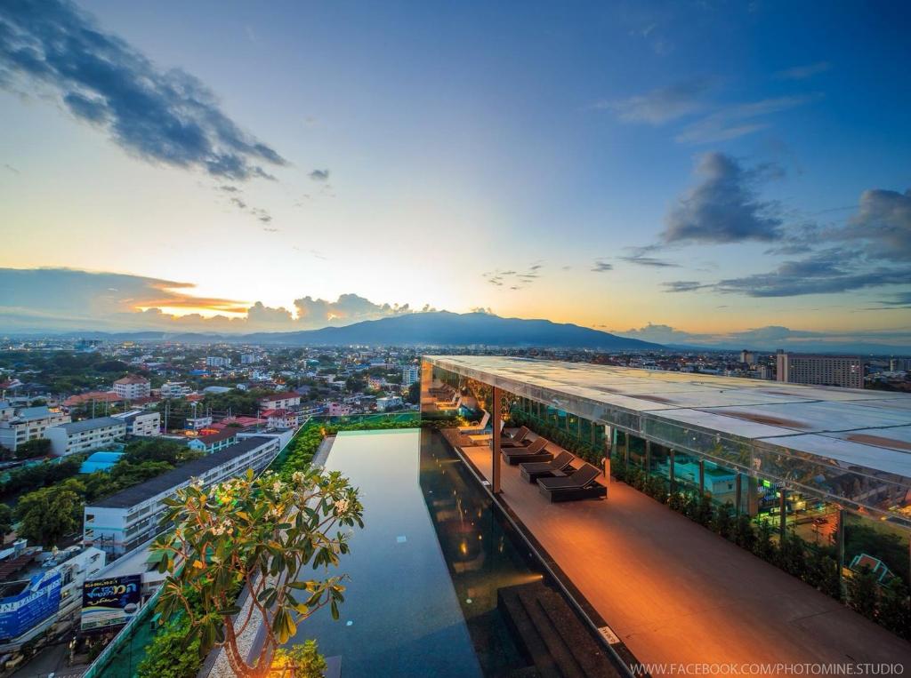 a building with a pool in the middle of a city at The Astra Chiang Mai family room in Chiang Mai