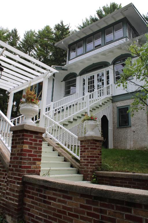 a white house with a white porch and stairs at The Hillside B&B. Home w/ Breakfast Service! in Wisconsin Dells