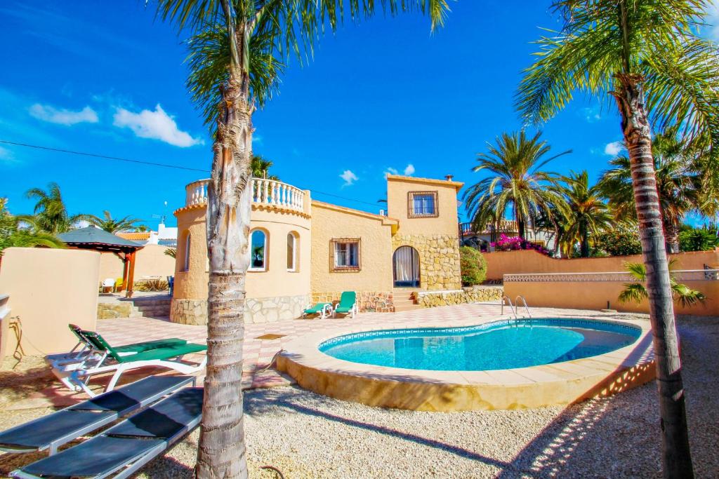 une villa avec une piscine et des palmiers dans l'établissement Cometa-86 - villa with private pool close to the beach in Calpe, à Empedrola