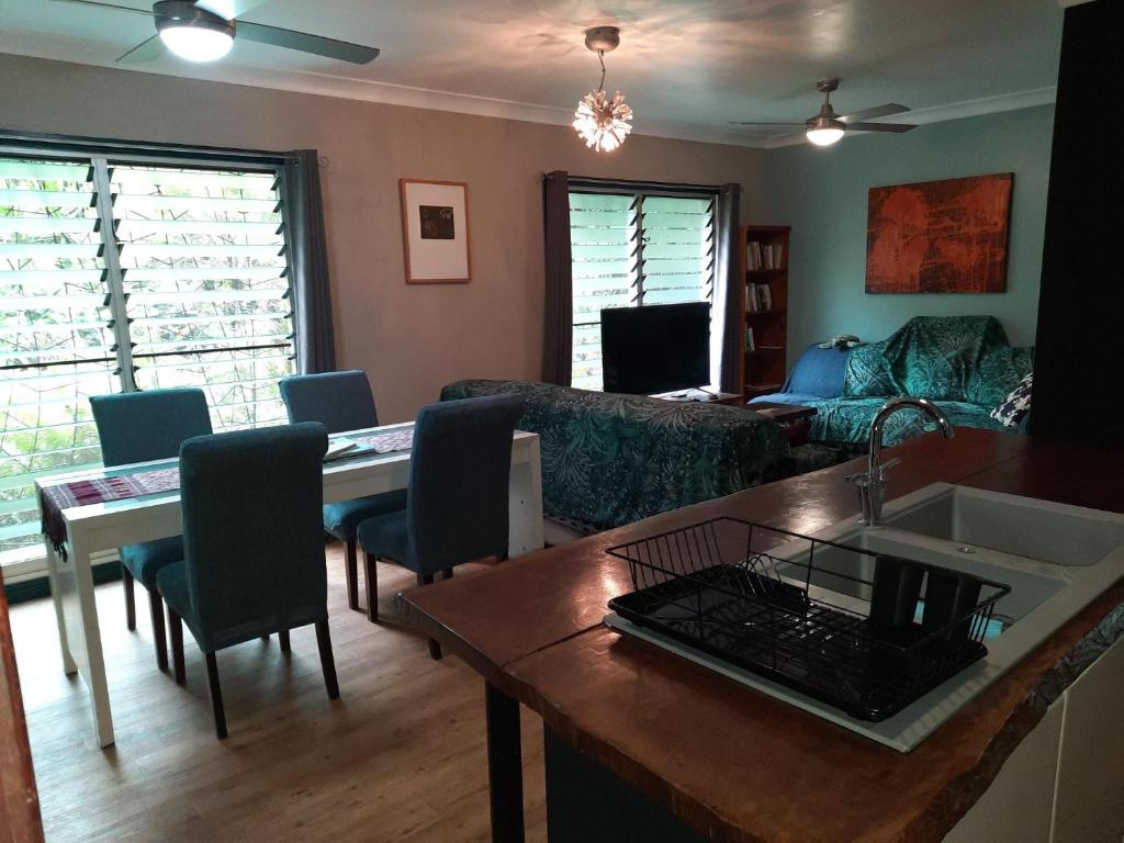 Daintree Rainforest Accommodation في Cow Bay: غرفة معيشة مع طاولة وأريكة