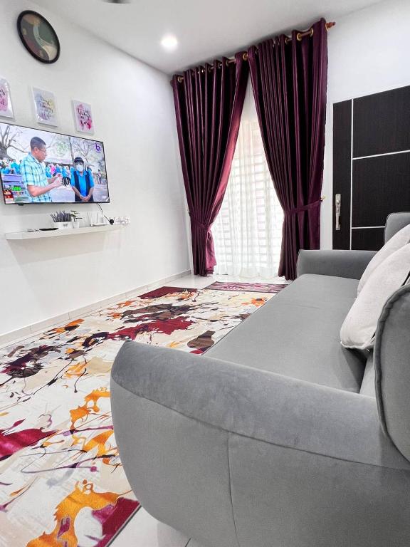 salon z łóżkiem i telewizorem na ścianie w obiekcie RAINA MUSLIM FRIENDLY HOMESTAY Perlis w mieście Arau