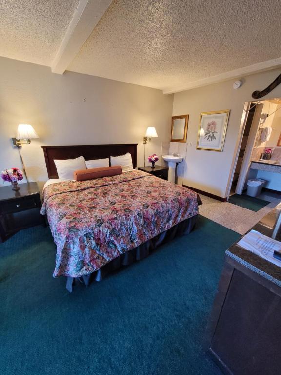 a hotel room with a large bed and a room with at Express Inn and Suites in Gastonia