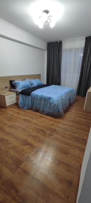 a bedroom with a bed and a wooden floor at Brown Aparts in Chişinău