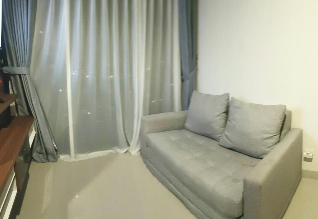 ein Sofa in einem Zimmer mit Fenster in der Unterkunft MM Property 