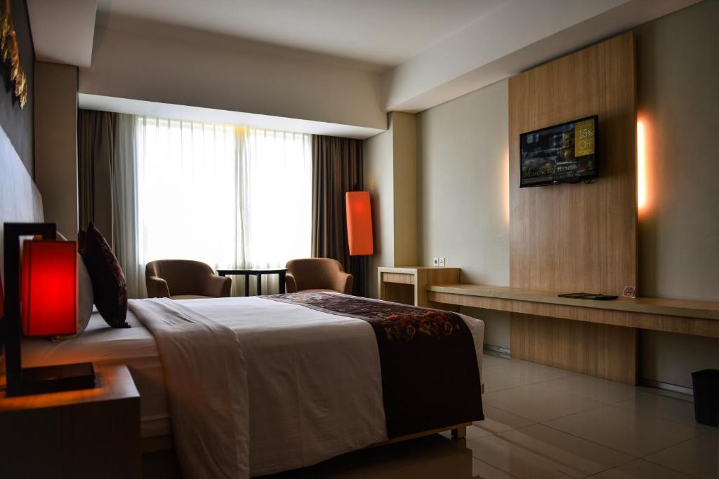 Postel nebo postele na pokoji v ubytování The Kana Kuta Hotel