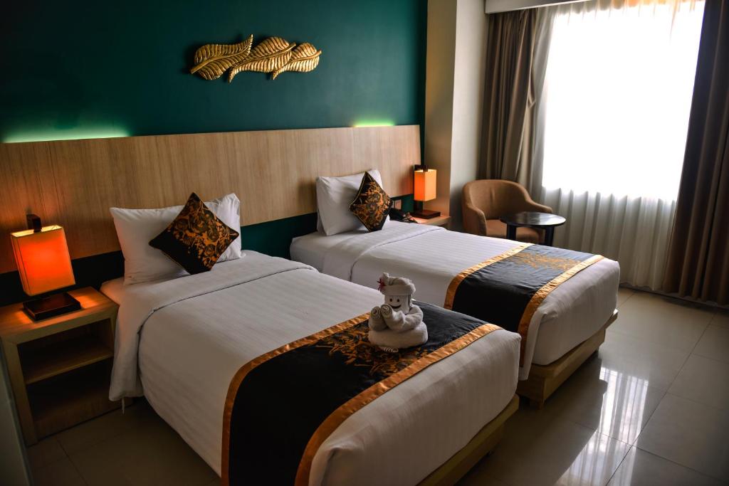 Postel nebo postele na pokoji v ubytování The Kana Kuta Hotel
