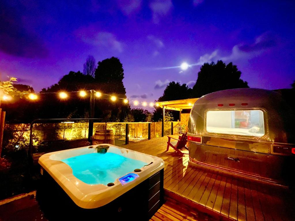 una cabaña estacionada en una terraza con bañera de hidromasaje en Frankie the Silver Bullet Airstream, en Katoomba