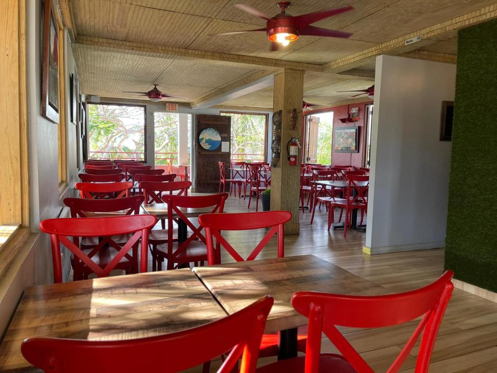 a dining room with red chairs and a table at Red Flamboyan Guesthouse and Restaurant in Rincon