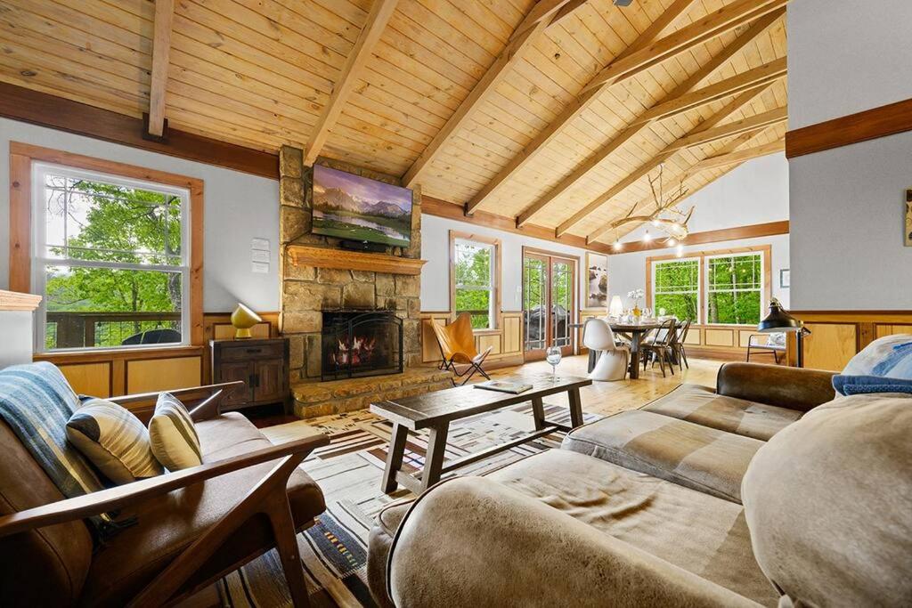 a living room with a couch and a fireplace at Chic private cabin w/ epic views & amenities! in Cove Creek Cascades