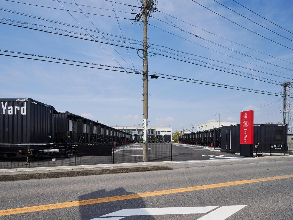 a row of train cars parked on the side of a street at HOTEL R9 The Yard Kaizu in Kaizu
