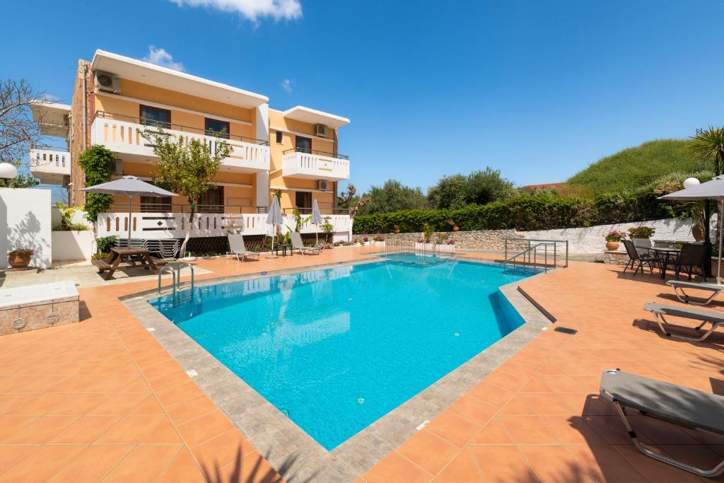 a swimming pool in front of a villa at Aphrodite Apartments in Kalyves