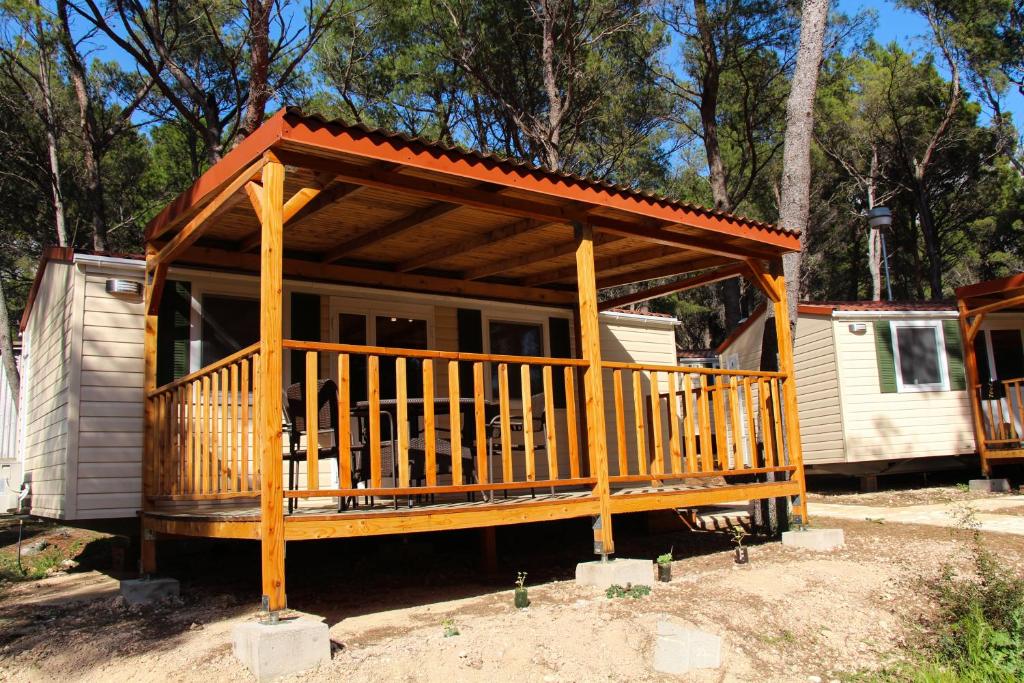 a small cabin with a large deck at Mobile Homes Holiday Dream in Ba&scaron;ka Voda