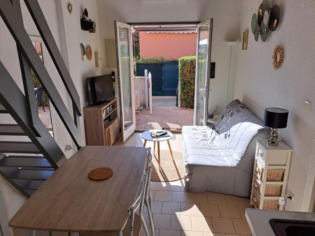 un petit salon avec un canapé et une table dans l'établissement Maisonnette, 5 Pers, 500m plage, Parking, Terrasse, au Cap d'Agde
