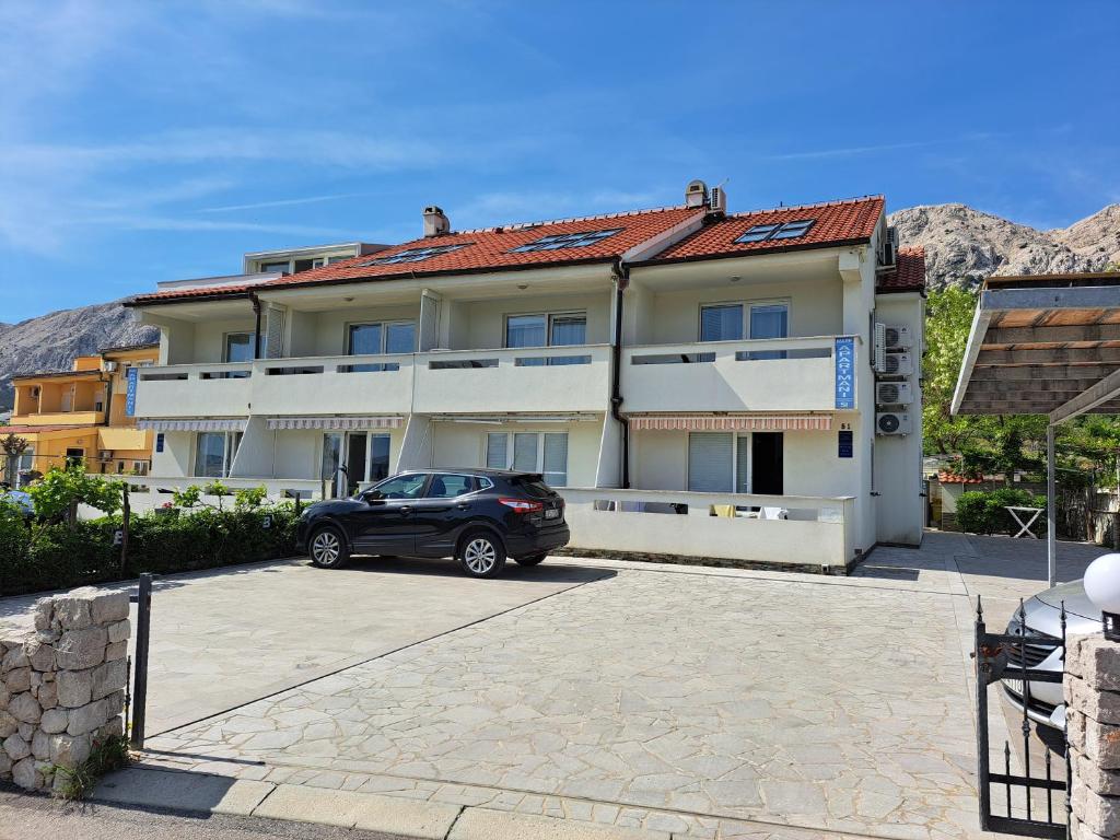 un'auto nera parcheggiata davanti a un edificio di Apartments Mare a Baška