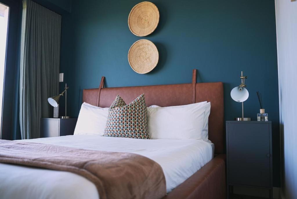sypialnia z dużym łóżkiem z niebieską ścianą w obiekcie Rose Gold @The Winchester w Kapsztadzie