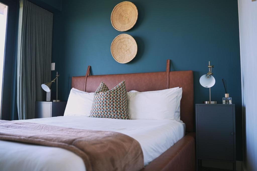 Un dormitorio con una cama grande con una pared azul. en Rose Gold @The Winchester, en Ciudad del Cabo