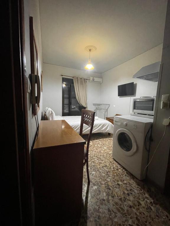 um pequeno quarto com uma cama e uma máquina de lavar roupa em The Beehive 2 em Mitilene