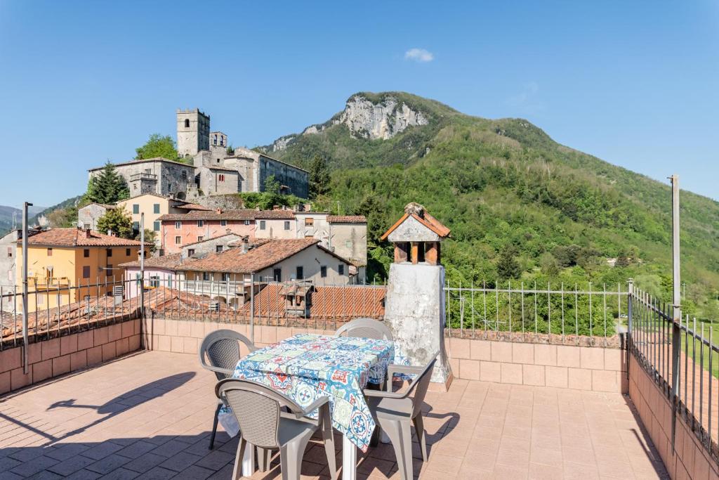 a table and chairs on a balcony with a mountain at La casa di Anita in Gallicano