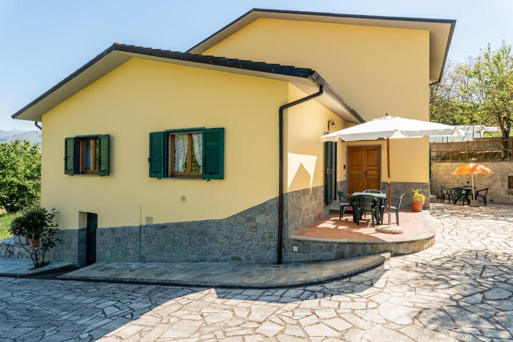 une maison avec une terrasse en face de celle-ci dans l'établissement Casa mia, à Castelnuovo di Garfagnana