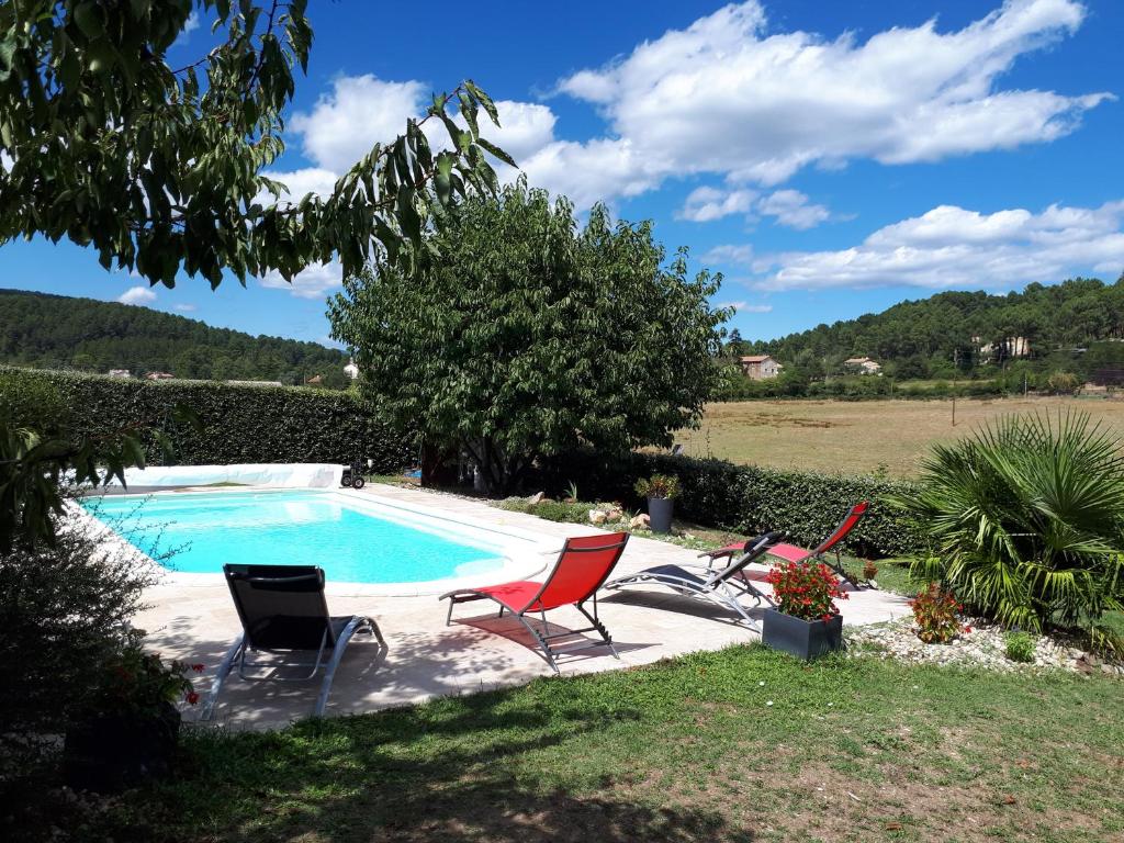 a swimming pool with two chairs and a table at Gîte la Pradelienne en Cévennes avec piscine privée 