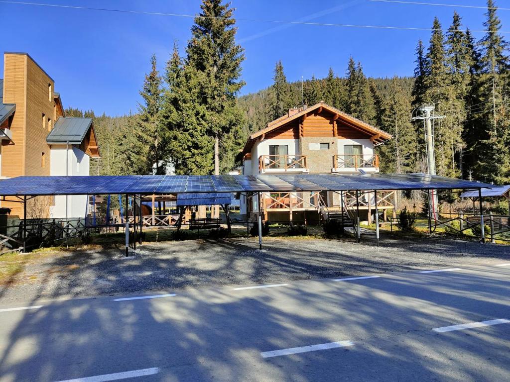 a pavilion in a parking lot in front of a house at Complex Transalpina Lac in Voineasa