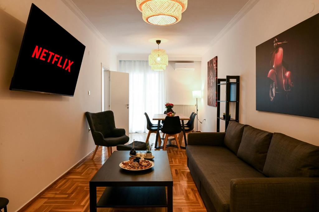 Thessaloniki Center Deluxe Apartment في سلانيك: غرفة معيشة مع أريكة وطاولة
