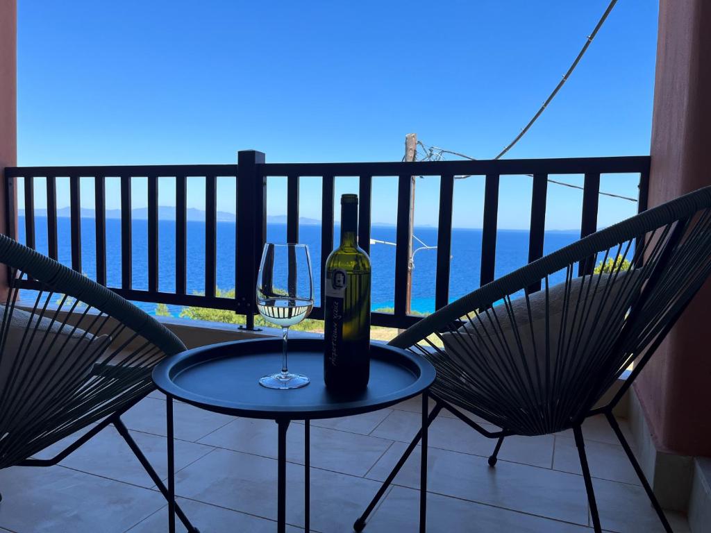 un bicchiere di vino seduto su un tavolo sul balcone di Sunrise Studio Afitos ad Áfitos