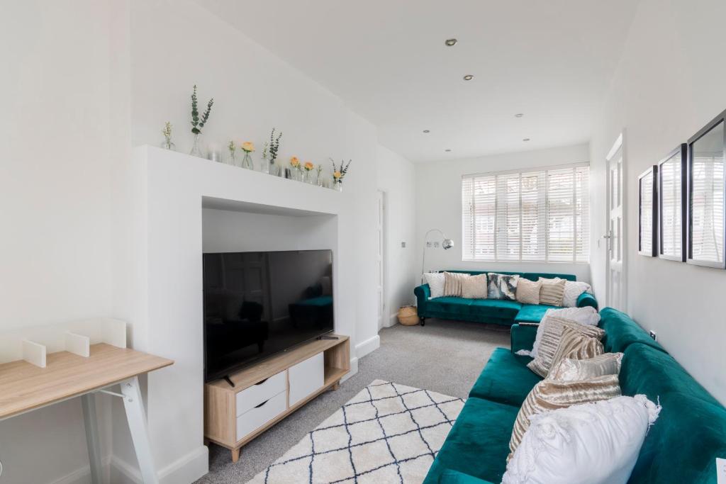 a living room with a couch and a television at Surrey Stays - 5bed house, sleeps 12, CR5, near Gatwick Airport in Coulsdon