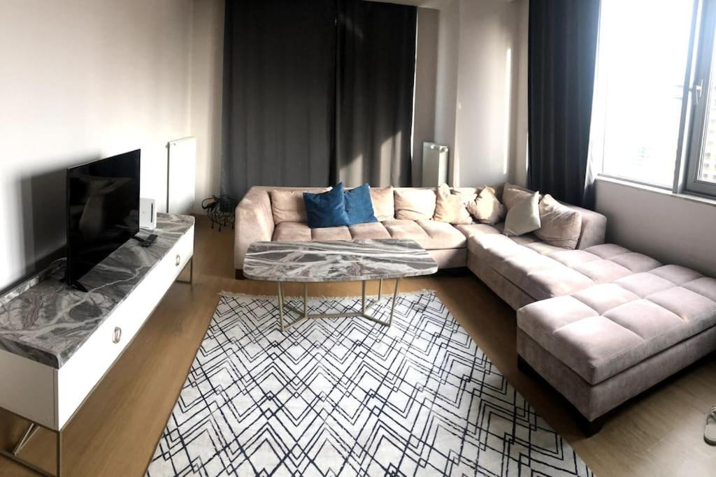 een woonkamer met een bank en een tv bij Modern mükemmel bir manzaralı in Istanbul