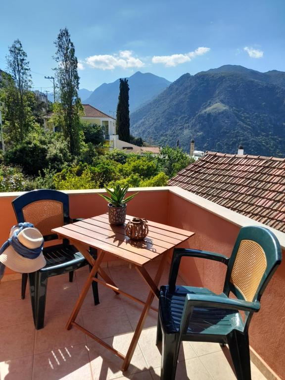 a wooden table and chairs on a patio with mountains at Thea's country house in Aryiroúpolis