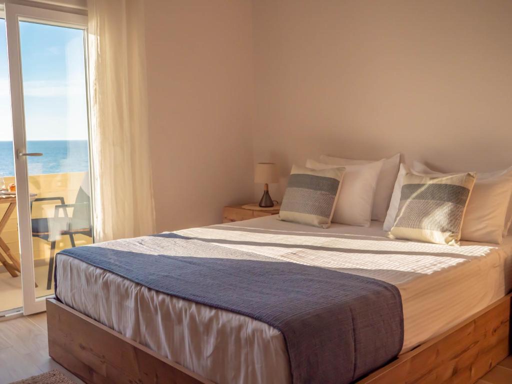 a bedroom with a bed with a view of the ocean at Mare Blue Bliss with SeaView by 8essentially in Heraklio